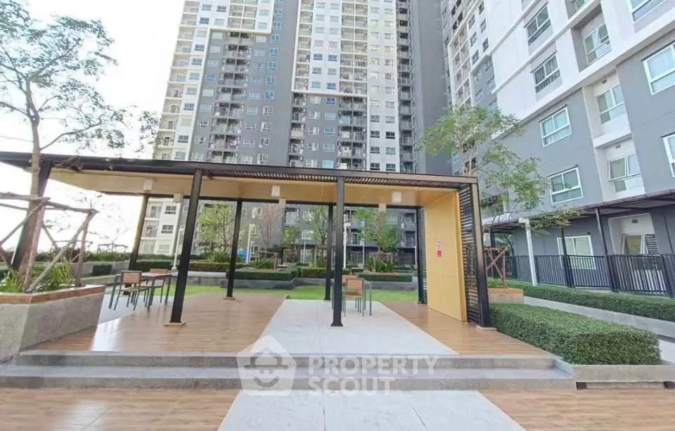 Modern apartment building with outdoor seating area and landscaped garden