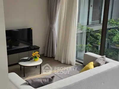 Modern living room with large windows and stylish decor, featuring a cozy sofa and a flat-screen TV.