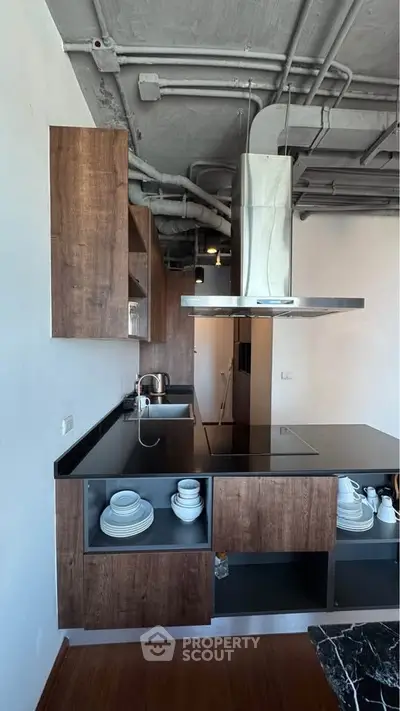 Modern industrial-style kitchen with sleek cabinetry and open shelving.