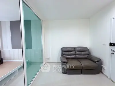 Modern living room with sleek glass partition and cozy leather sofa