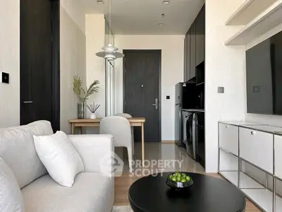 Modern living room with sleek furniture and open kitchen layout in a stylish apartment.