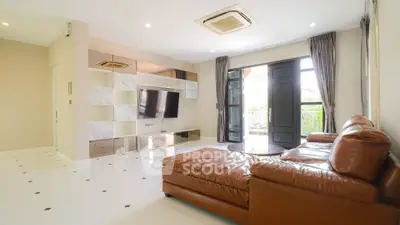 Spacious living room with leather sofa and modern entertainment center