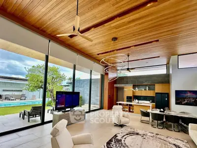 Luxurious modern living room with open kitchen, high ceilings, and pool view, perfect for entertaining.