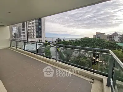 Spacious balcony with stunning ocean view in modern high-rise building.