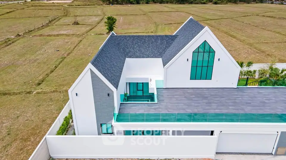 Modern luxury home with unique architecture and expansive rooftop terrace in serene countryside setting.