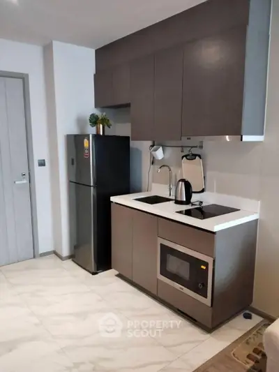 Modern kitchen with sleek cabinets and appliances in a compact layout