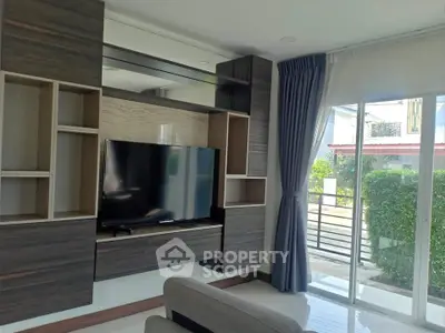 Modern living room with sleek TV unit and large window view