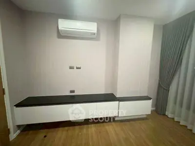 Modern minimalist living room with sleek air conditioning and stylish cabinetry.