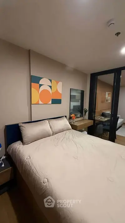 Modern bedroom with stylish decor and cozy ambiance, featuring a comfortable bed and contemporary artwork.
