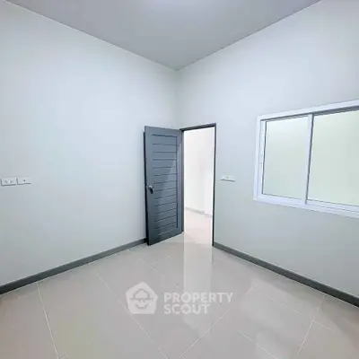 Minimalist empty room with tiled floor and modern door, perfect for customization.