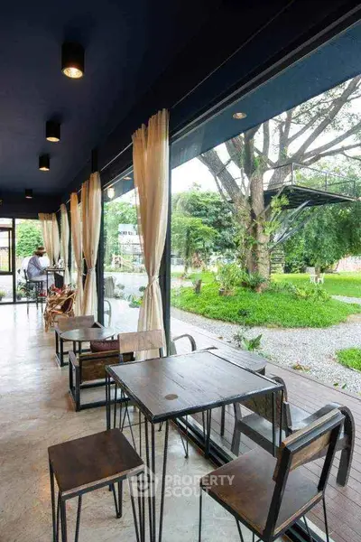 Charming cafe-style seating area with garden view and modern decor.