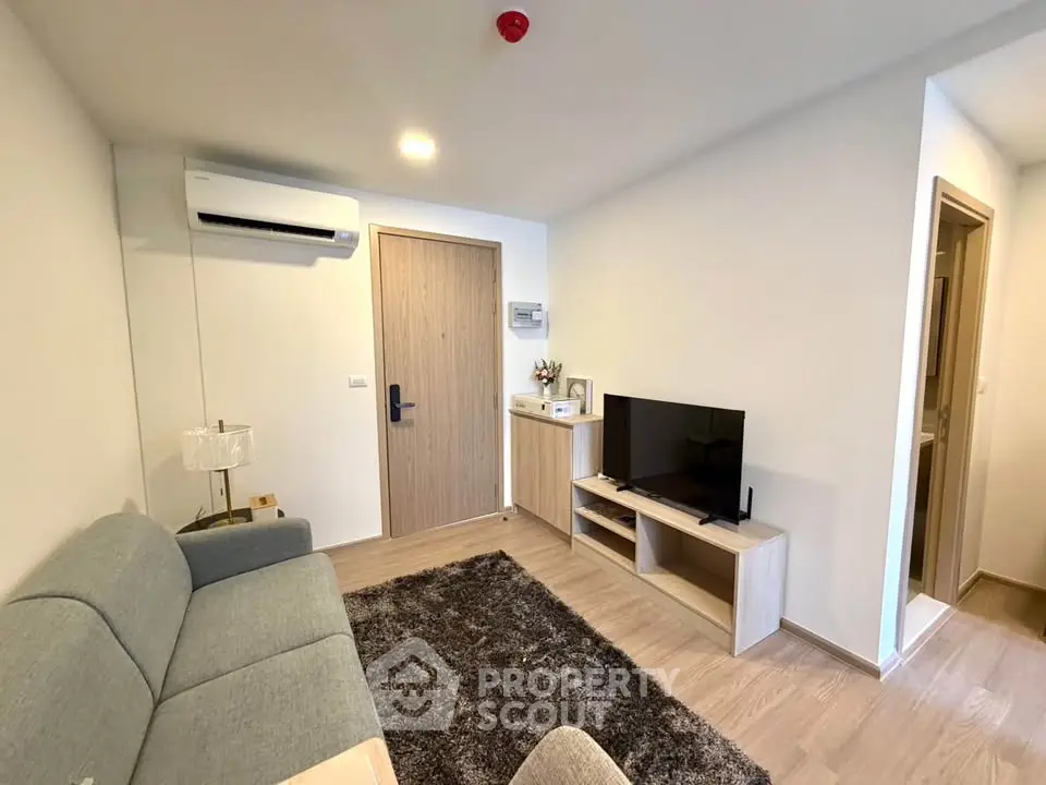 Modern living room with cozy sofa, TV, and air conditioning in a stylish apartment.