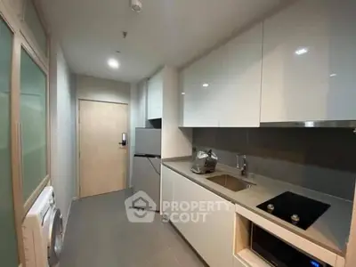 Modern kitchen with sleek cabinets, built-in appliances, and compact layout