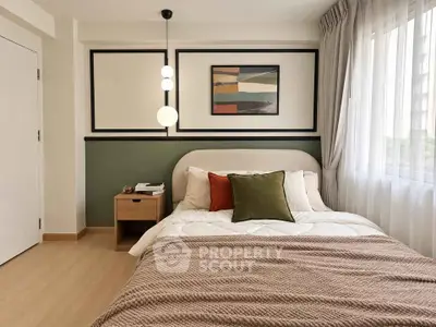 Modern bedroom with stylish decor and natural light, featuring a cozy bed and elegant wall art.
