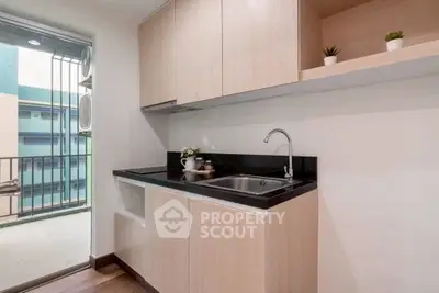 Modern kitchen with sleek cabinetry and balcony view, perfect for urban living.