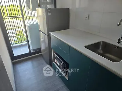 Modern compact kitchen with sleek cabinetry and balcony view
