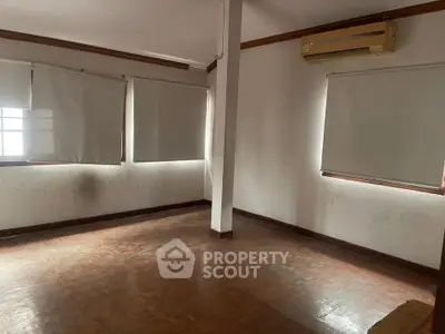 Spacious empty room with wooden flooring and air conditioning, ideal for customization.