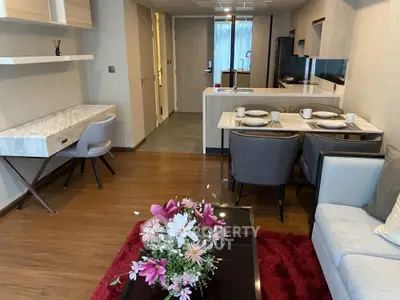 Modern living room with open kitchen, stylish furniture, and elegant decor in a cozy apartment.