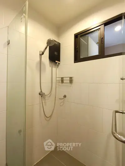 Modern bathroom with sleek shower and glass partition in contemporary apartment.