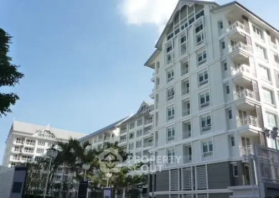 Modern residential building with elegant architecture and spacious balconies.