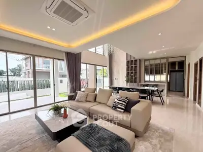 Spacious modern living room with large windows and elegant decor in a luxury home.