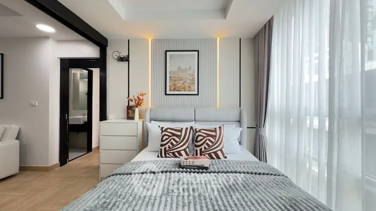 Modern bedroom with stylish decor and large windows offering natural light.