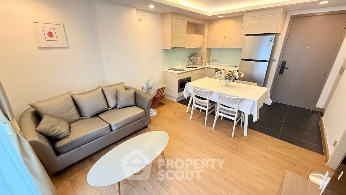 Charming open-layout living room with modern kitchen and cozy dining area, perfect for urban living.