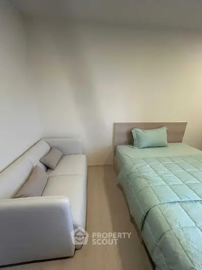 Cozy bedroom with modern bed and stylish sofa, perfect for relaxation.