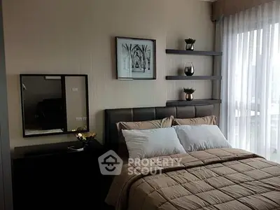 Elegant bedroom with modern decor and large window offering natural light.