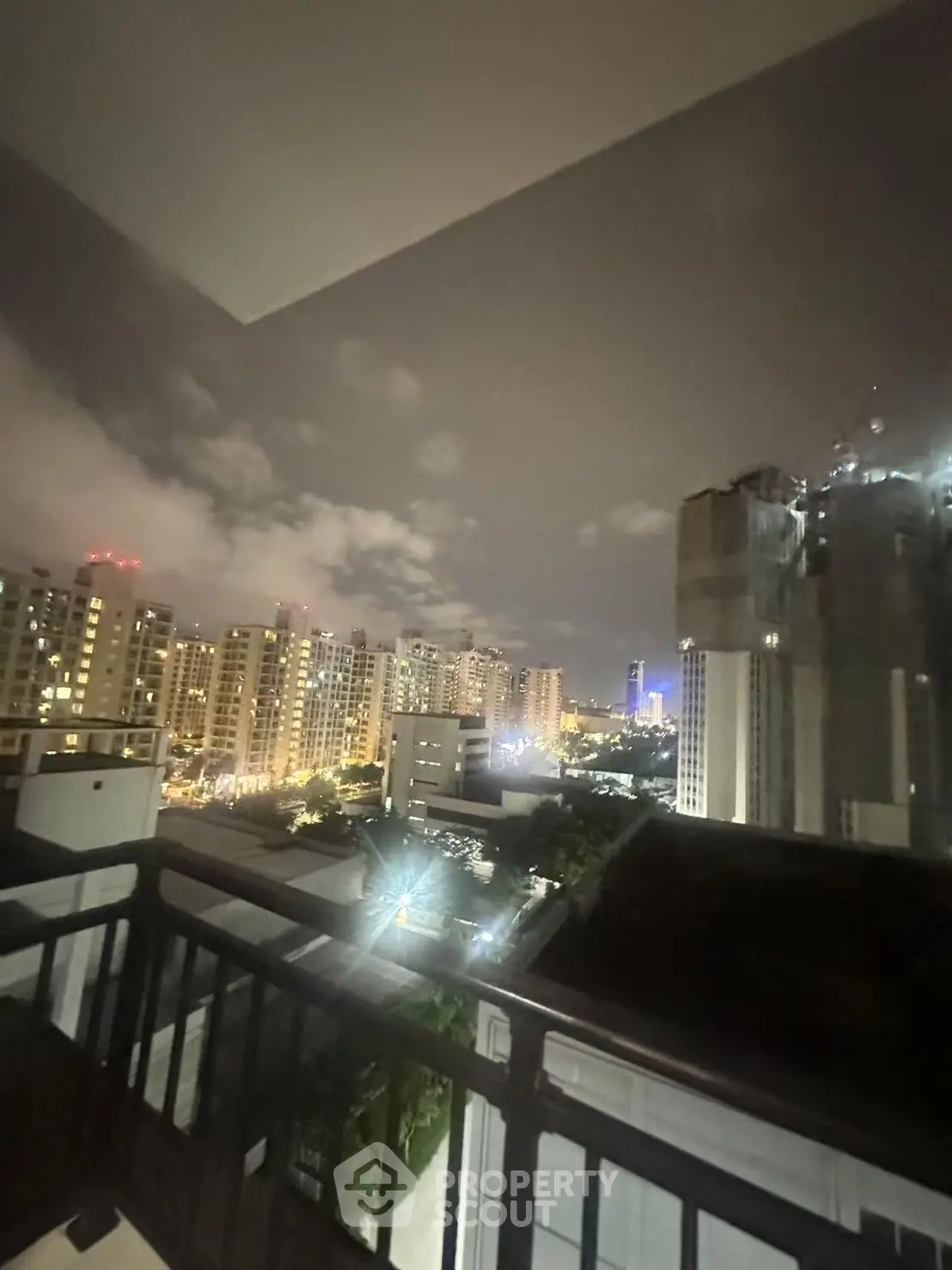 Stunning cityscape view from a high-rise balcony at night, showcasing urban living.