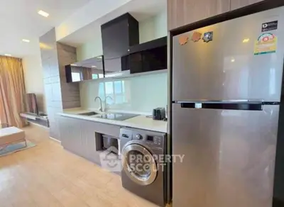 Modern kitchen with sleek appliances and washing machine in open layout