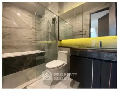 Luxurious modern bathroom with glass shower and elegant marble finishes.