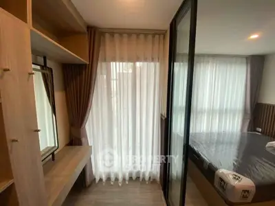 Modern bedroom with floor-to-ceiling windows and elegant curtains, featuring a stylish wardrobe and cozy ambiance.