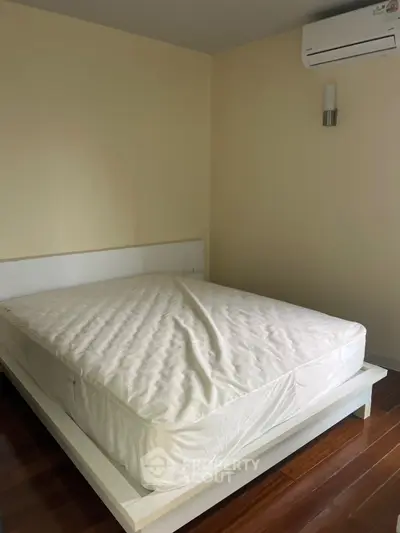 Spacious bedroom with modern bed and air conditioning, perfect for comfort and relaxation.