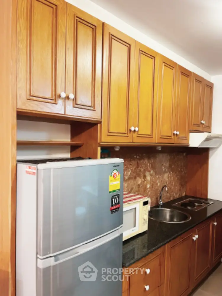 Charming kitchen with wooden cabinets and modern appliances, perfect for culinary enthusiasts.