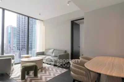 Modern living room with large windows and city view, featuring stylish furniture and contemporary design.