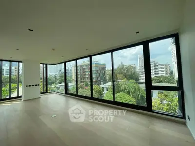 Spacious corner unit with floor-to-ceiling windows offering a stunning city view in a modern apartment.