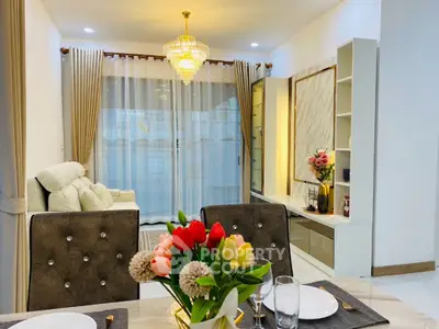 Elegant living room with chandelier and modern decor, perfect for stylish gatherings.