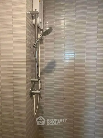 Modern bathroom shower with sleek tile design and efficient water heater.