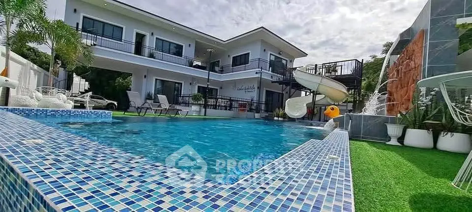 Luxurious modern villa with pool and slide, perfect for family entertainment.