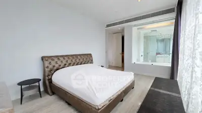 Luxurious bedroom with elegant design and large window overlooking modern bathroom.