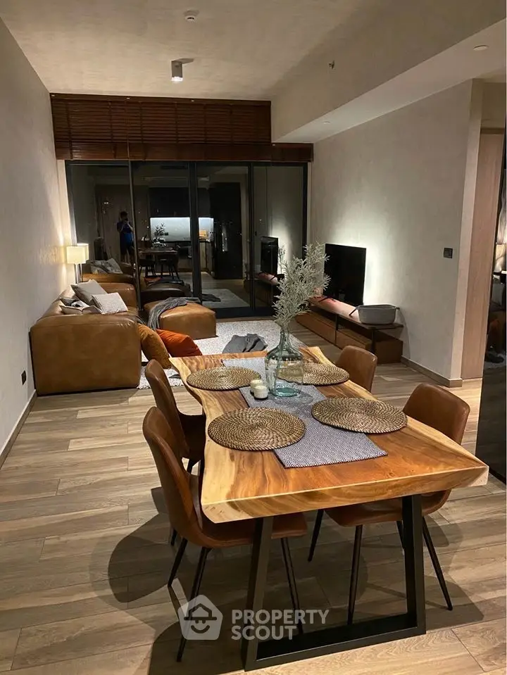 Modern open-plan living and dining area with stylish wooden furniture and cozy ambiance.