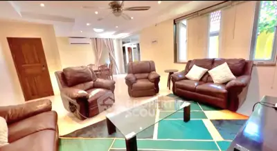 Spacious living room with leather sofas and modern decor, perfect for family gatherings.