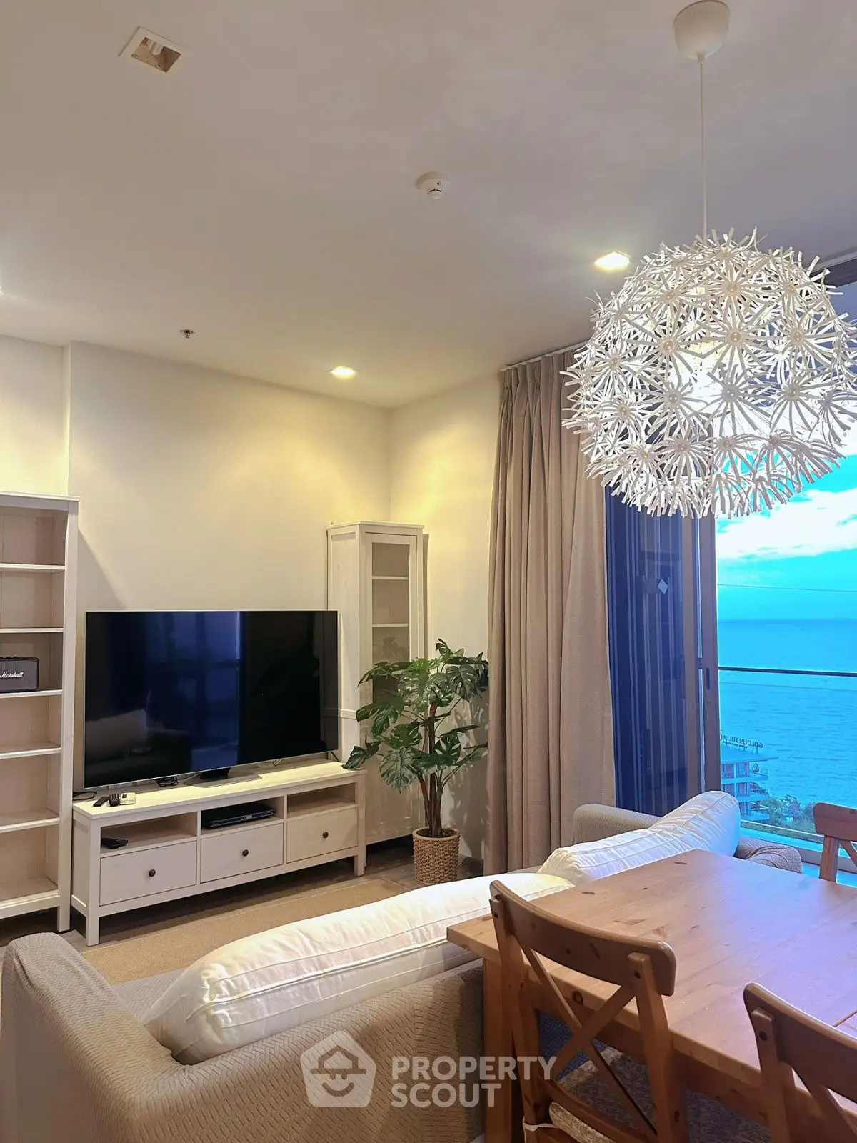 Stunning living room with ocean view, modern decor, and elegant lighting.