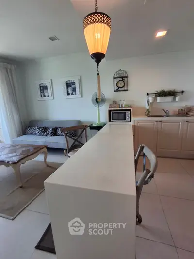 Chic open-layout kitchen with stylish lighting and cozy living area, perfect for modern living.