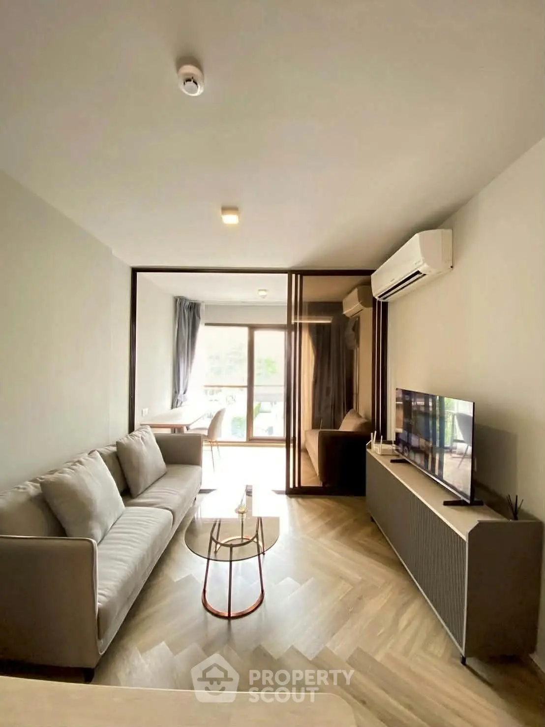 Modern living room with sleek design, featuring a cozy sofa, stylish TV unit, and large windows for natural light.