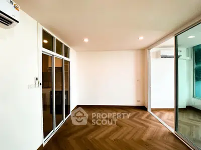 Spacious modern living room with wooden flooring and large glass doors