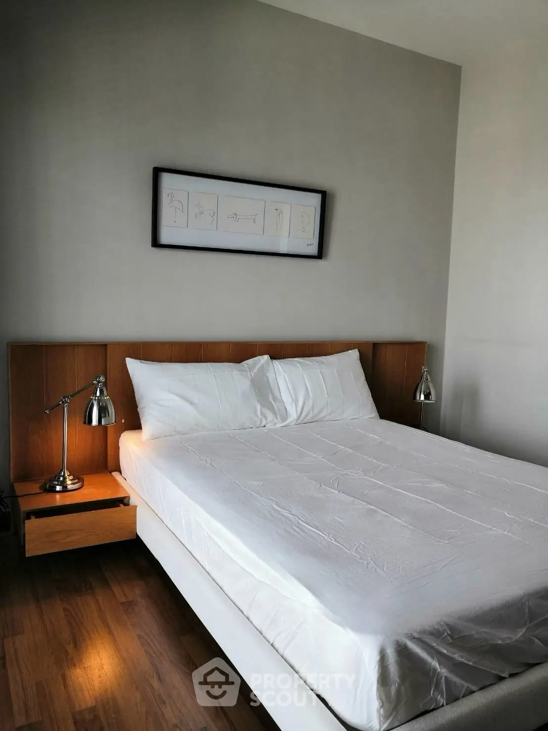Modern bedroom with sleek wooden flooring and stylish bedside lamps