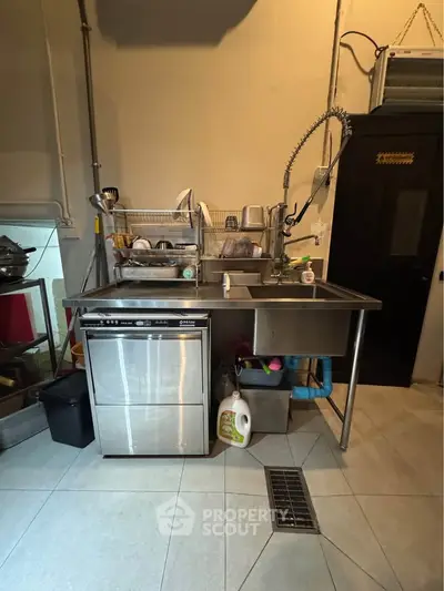 Spacious kitchen with stainless steel sink and dishwasher, ideal for modern culinary needs.