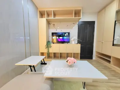 Modern living room with sleek furniture and built-in storage, featuring a stylish TV setup.